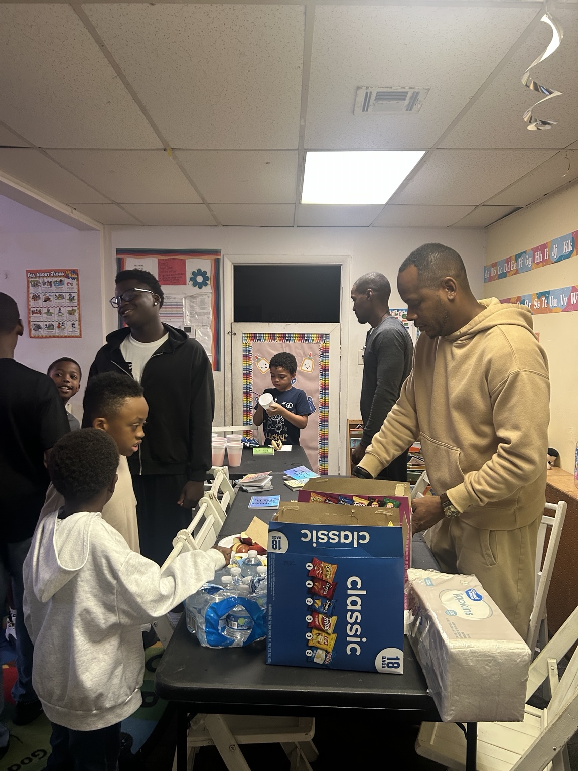 Coach Wells and the boys group spending time together at a community gathering